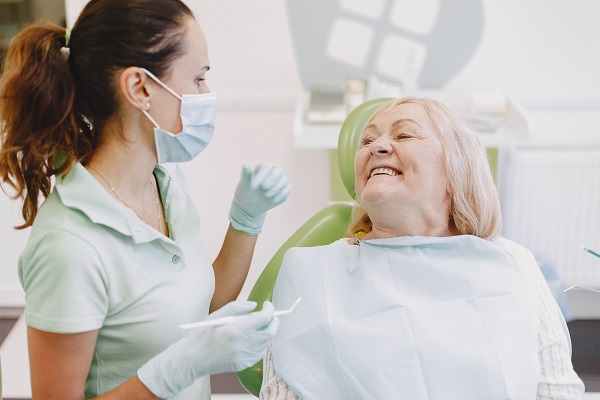 Dentist looking her old patient with tools Anziana durante una visita dal dentista.