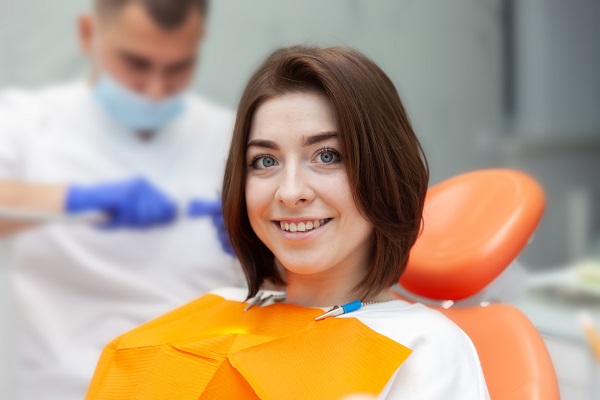 Paziente sorride sulla poltrona del dentista.
